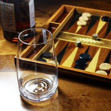 Load image into Gallery viewer, An Amphitrite mouth-blown highball glass, pictured with a wooden backgammon board, on a wooden surface,