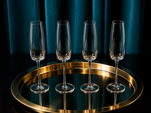 Load image into Gallery viewer, Set of 4 Amphitrite Champagne Flutes on a gold tray, pictured in-front of a blue curtain.