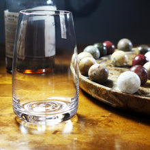 Load image into Gallery viewer, An Amphitrite mouth-blown glassware tumbler, pictured with marbles and rum.